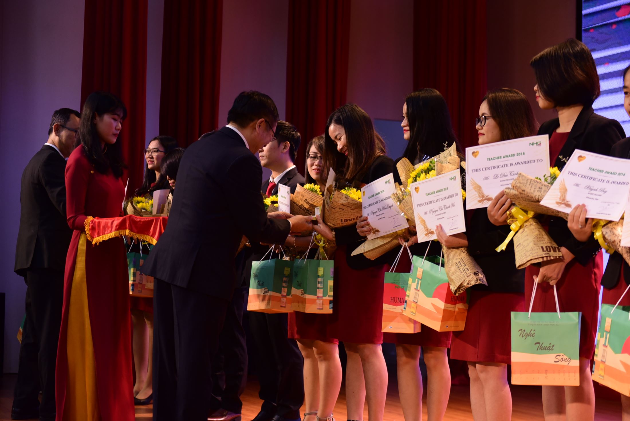 Dr. Dinh Quang Nuong gives flowers, Human books and gold heart badges to teachers of Teacher Award 2018 prize