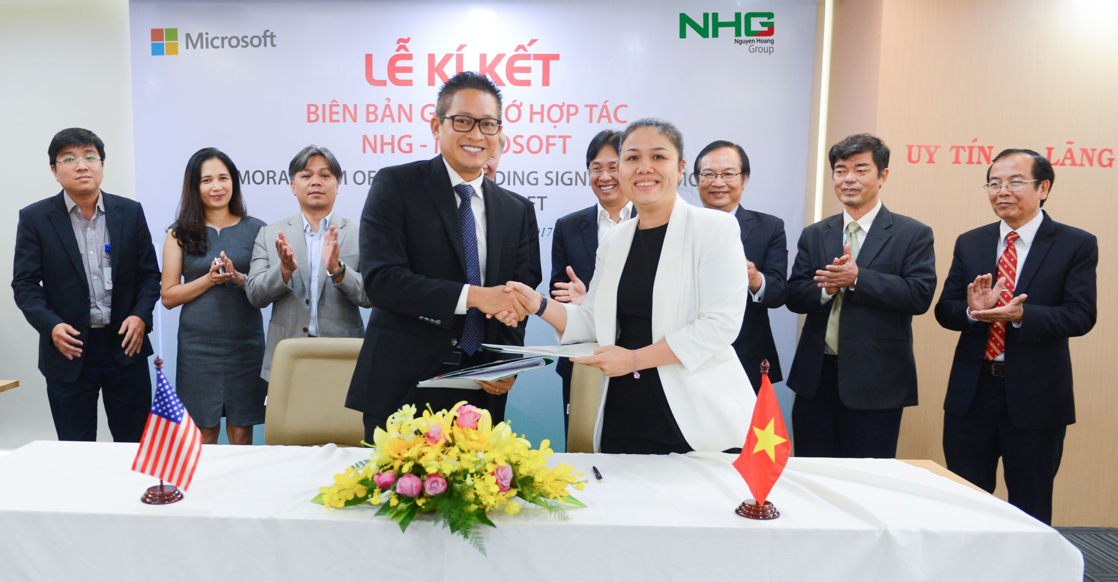 Ms. Hoang Nguyen Thu Thao, CEO of NHG and Mr. Vu Minh Tri, General Director of Microsoft Vietnam shaking hands after the signing ceremony at NHG office.