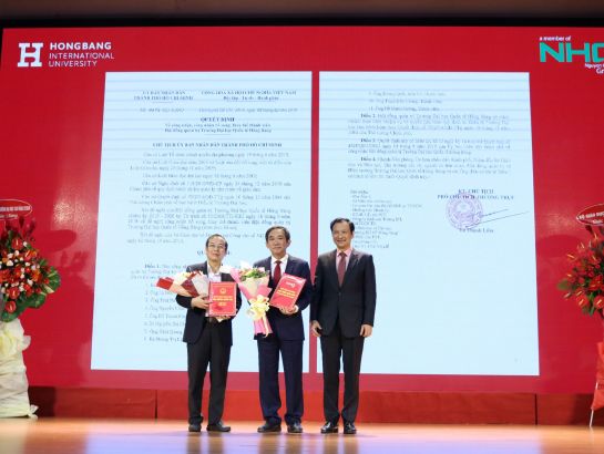 Mr. Le Hoai Nam – Deputy Director of HCMC Department of Education & Training (DoET) awards the decision appointing Associate Professor, Dr. Ho Thanh Phong to be deputy CEO of Nguyen Hoang Group (NHG) and Dr. Do Manh Cuong to be a member of management board of HIU.
