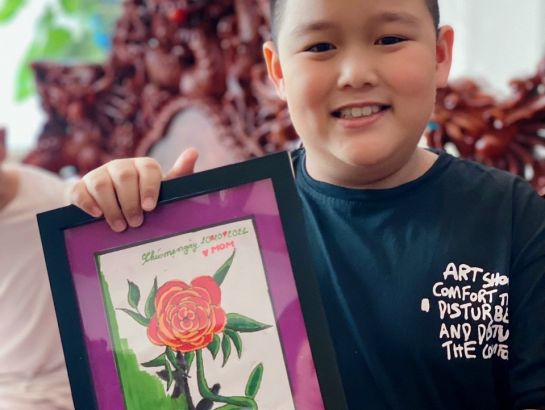 Doan Vy Nguyen, UKA Gia Lai student, with his handmade painting for his mother.